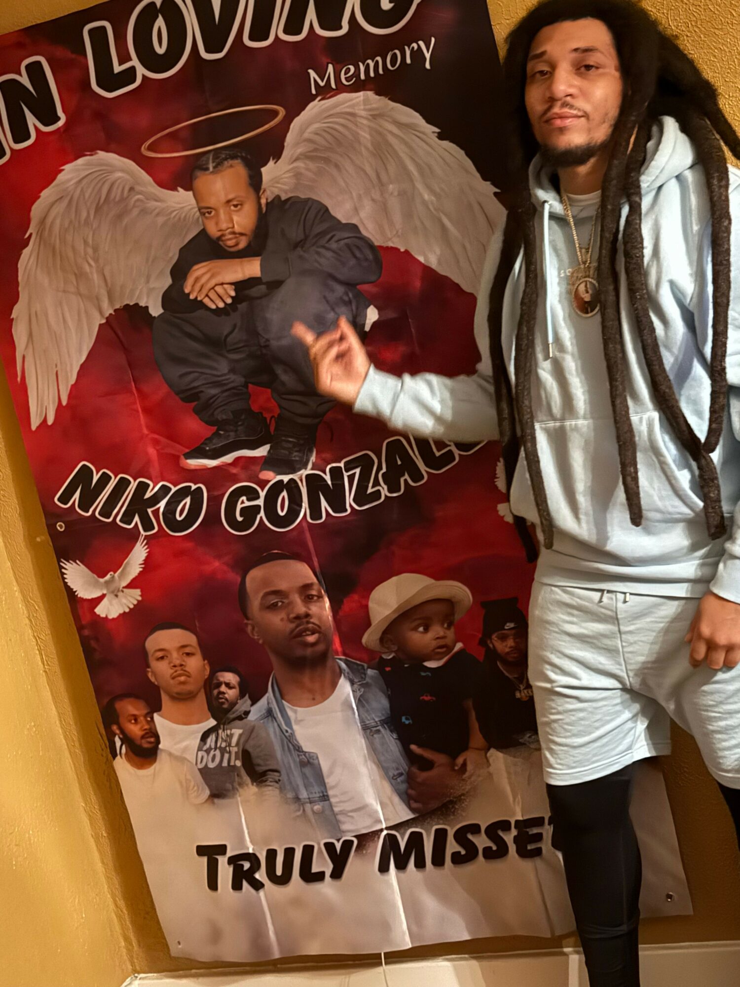 Woman standing next to a large movie poster featuring several characters, including a person in a Santa hat, with text in a foreign language.