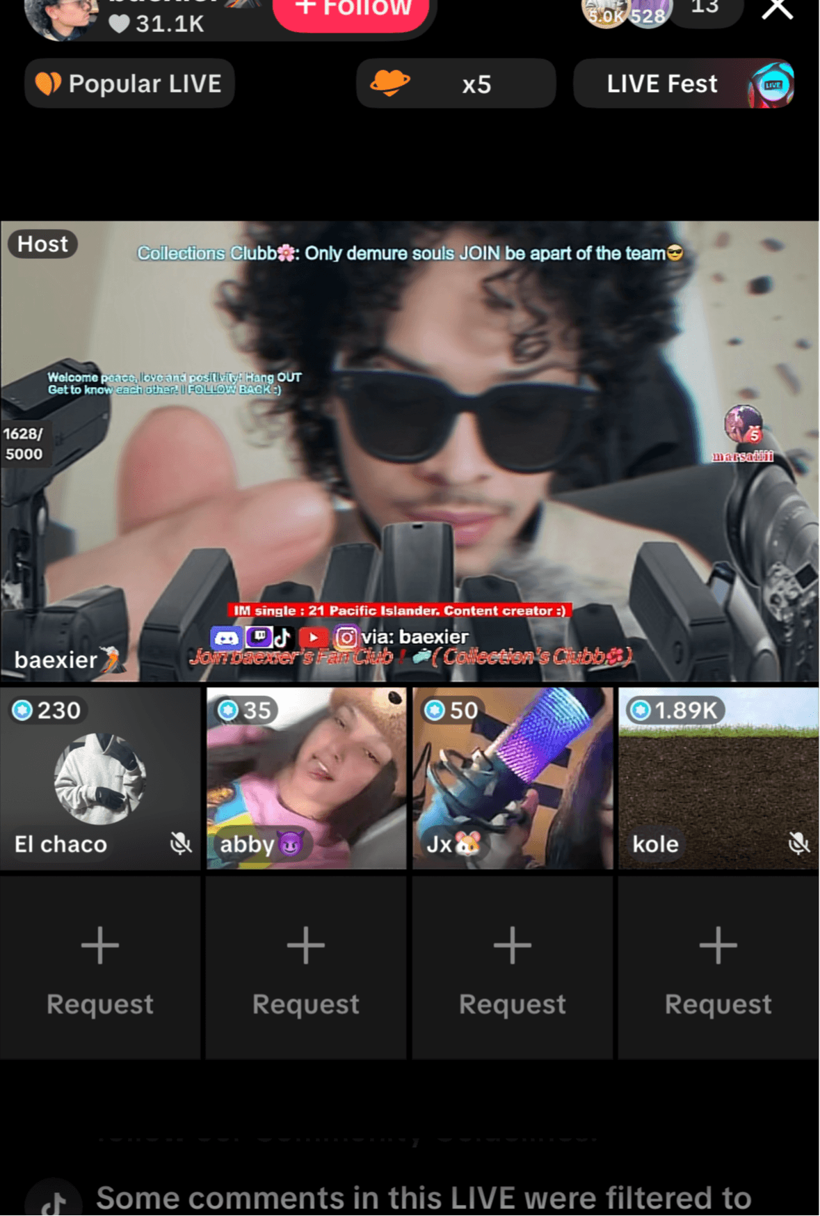 Person with curly hair and sunglasses speaking into microphones during a live stream, with comments and icons visible.