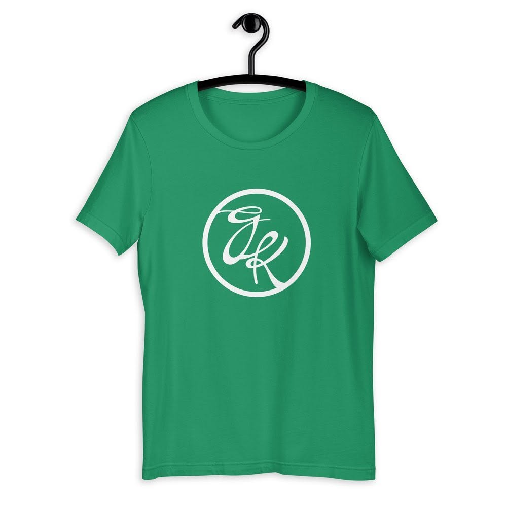 Green T-shirt with a white circular logo and stylized initials inside, hanging on a black hanger.
