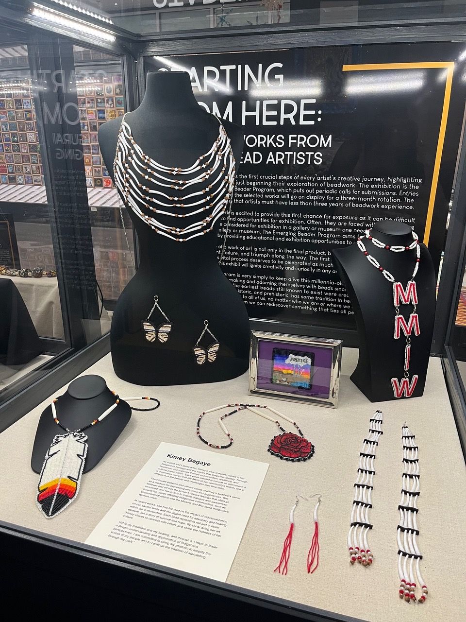 Display of jewelry and accessories including necklaces, bracelets, and a small electronic device on a table.