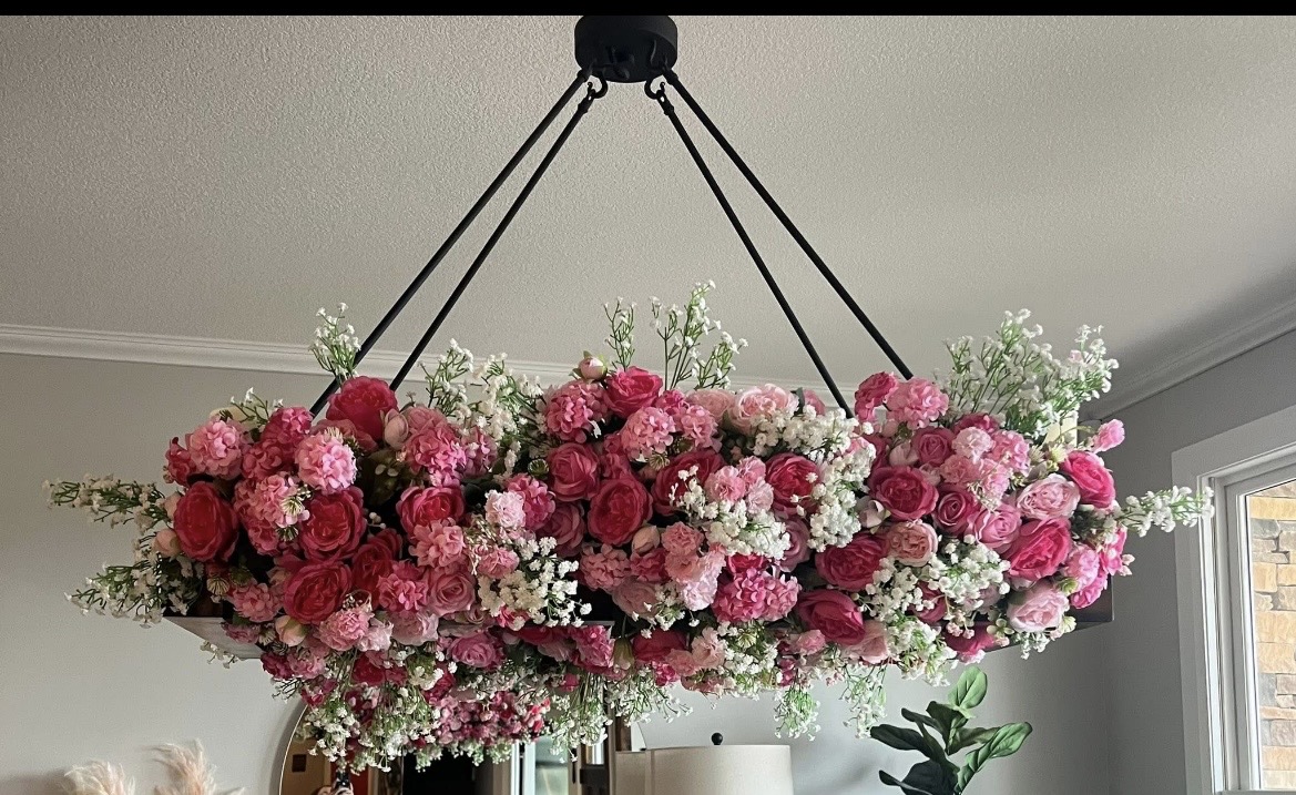 Hanging floral arrangement with pink and white flowers, suspended from ceiling, indoors.