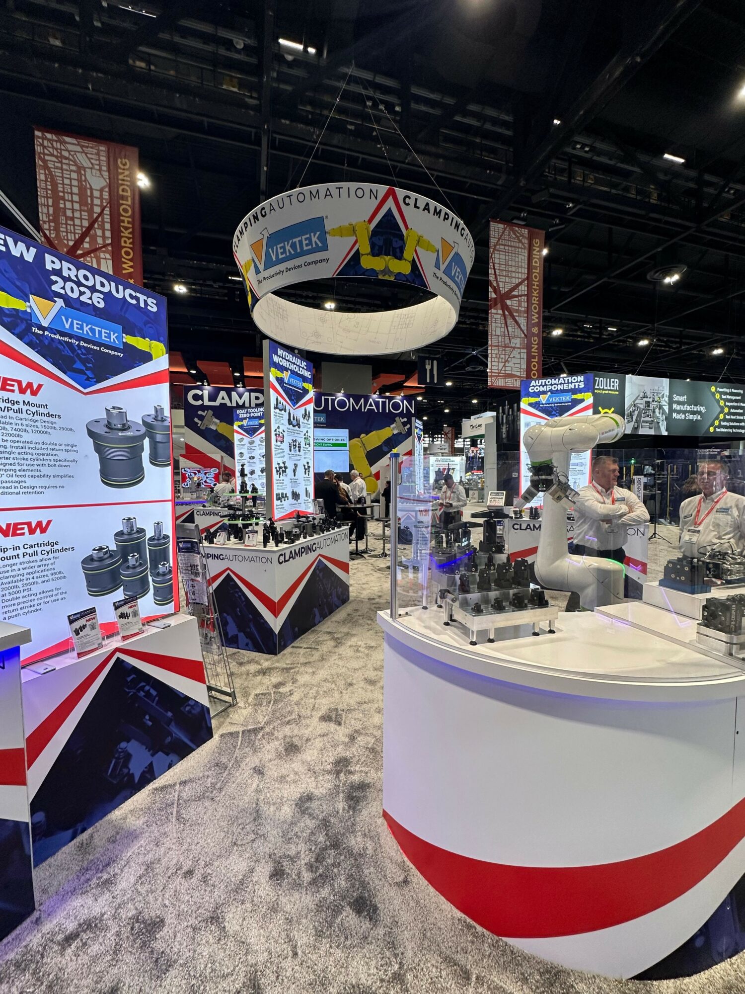 Trade show booth with displays, a person, and promotional materials inside a large exhibition hall.
